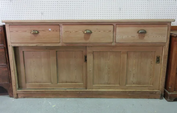 A large pine dresser base, with three drawers and a pair of sliding panel doors, 182cm wide x 91cm high.  D10