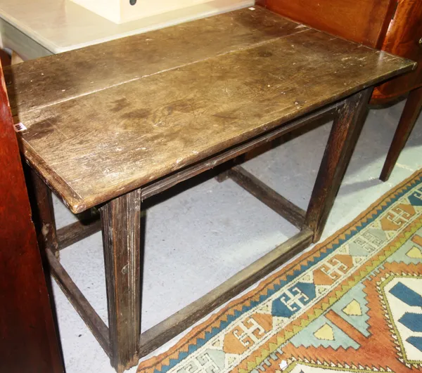 An early 18th century oak side table, the cleated twin plank top on four channelled square supports, united by perimeter stretcher, 61cm x 110cm.  C2