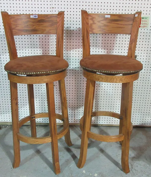 A pair of 20th century oak bar back tall swivel stools, 110cm high.  G8