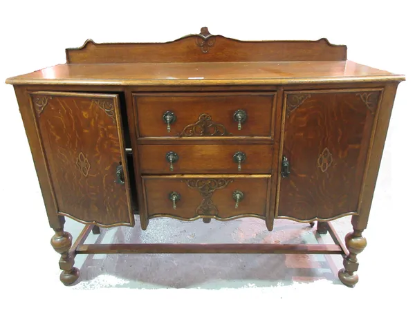 A mid-20th century oak bowfront sideboard, with three drawers flanked by cupboards, 137cm wide. C9