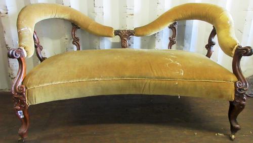 A Victorian carved walnut framed double spoon back sofa, with concave seat on scroll supports, 150cm wide x 84cm high.   J5