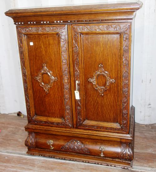 An early 20th century oak side cabinet, with pair of panelled doors enclosing haberdashery style drawers, 80cm wide.  D1
