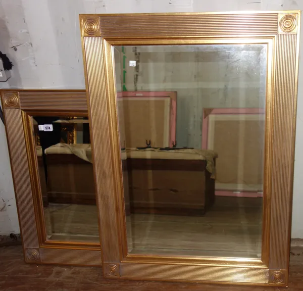 A pair of 20th century gilt framed wall mirrors, the fluted frames with bulls eye corners about the bevelled mirror plate, 69cm wide x 94cm high.   A2