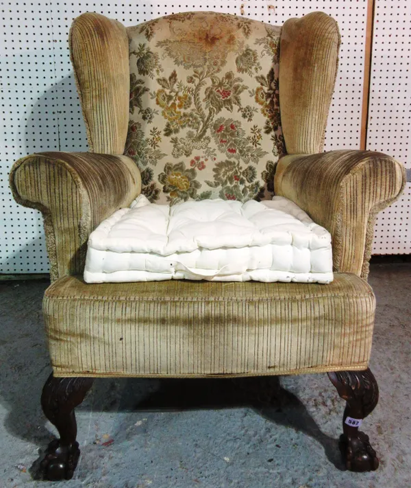 A George III style wing back armchair on hairy claw and ball feet.  K5