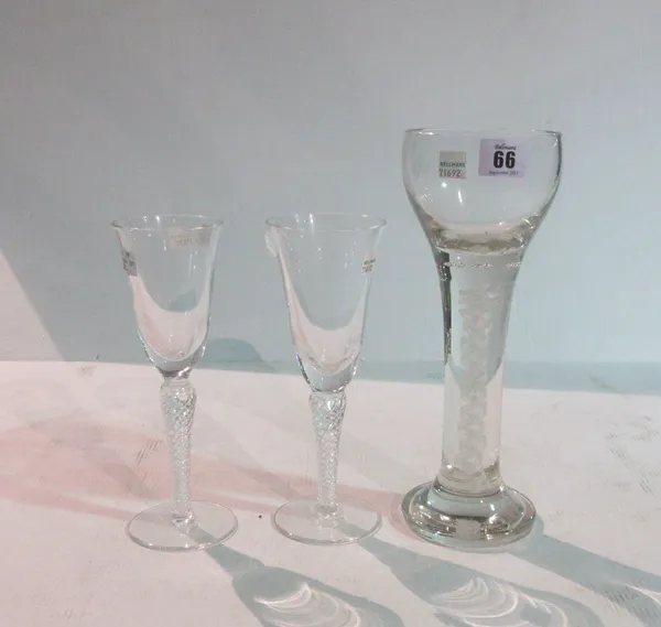 A large modern wine glass, possibly Whitefriars, with an opaque twist inclusion to the stem, on a circular foot, 27.7cm high and two modern wine glass