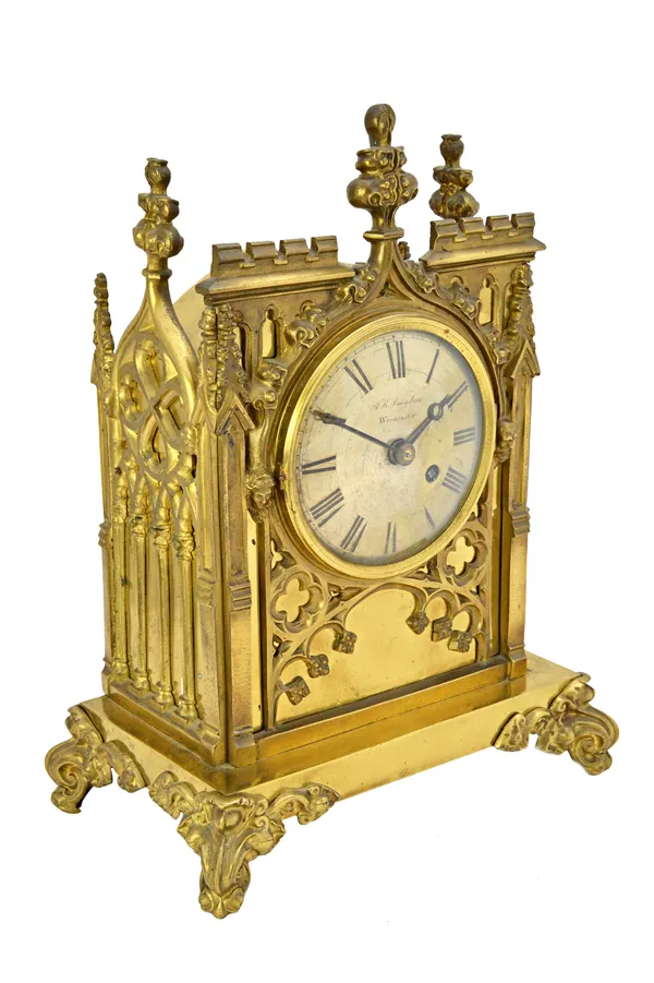 A gilt brass cased mantel clock, 19th century, of Gothic cathedral form, the silvered dial detailed 'J.H. SAUNDERS WARMINSTER', with a single fusee mo