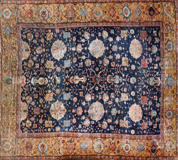 A Ziegler carpet, Persian, the indigo field with a central rosette and allover bold flowerheads, motifs and floral sprays, a wide golden brown border