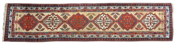 A Karajar runner, Caucasian, the fawn field with six hooked diamonds, pairs of supporting plants, three borders, 440cm x 100cm.  Illustrated