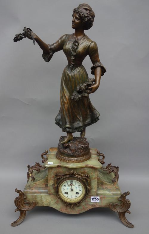 An onyx and spelter figural mantel clock garniture, early 20th century, the female figure titled 'Les Chrysanthemes', with matching five branch candel