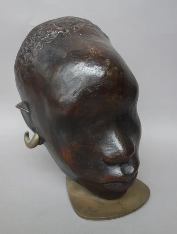 A Hagenauer patinated bronze African woman's head, circa 1930, with shaped earrings, on a bronze base stamped 'Hagenauer Wien, Made in Vienna, Austria