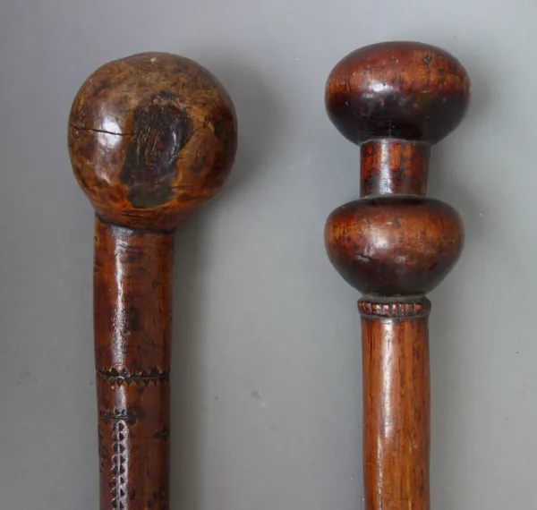 An unusual hardwood walking stick, probably African, late 19th century, with spherical carved pommel and matching knop, over a tapering shaft, 129cm l