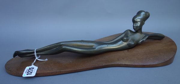 A Hagenauer patinated bronze model of a recumbent African female nude, circa 1930, mounted on a shaped walnut base, stamped marks to underside, 42cm w