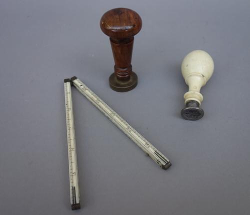 A Victorian carved ivory seal, with a steel matrix and shield shaped crest, 8cm long, a turned walnut seal with bronze matrix and ornate shield form c