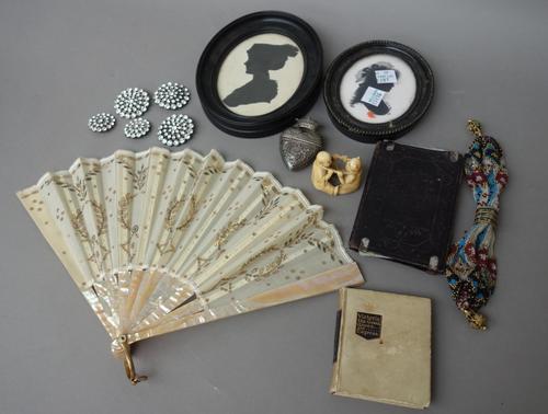 A quantity of collectables, including; two oval silhouettes, a silver heart shaped vesta, two fans, a Japanese ivory figural netsuke, dated 1882 (3.5c