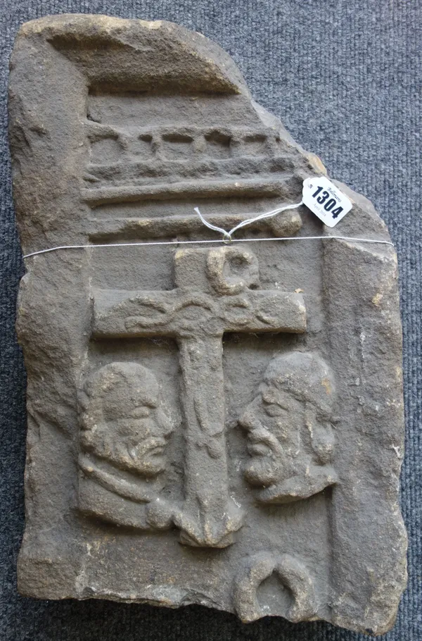 A reconstituted stone fragment depicting a central crucifix flanked by opposing figural busts (a.f), 41cm x 27cm.