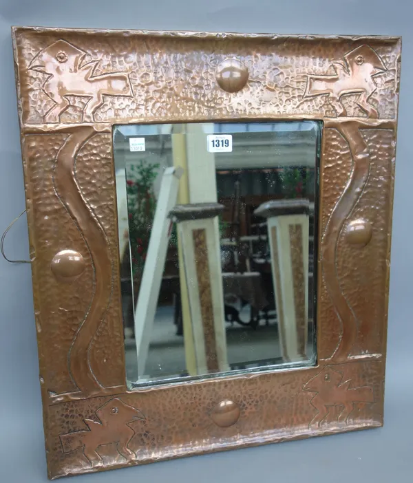A Newlyn style copper framed rectangular wall mirror, with inset bevelled glass plate, the wide border embossed with four stylised dragons against a b