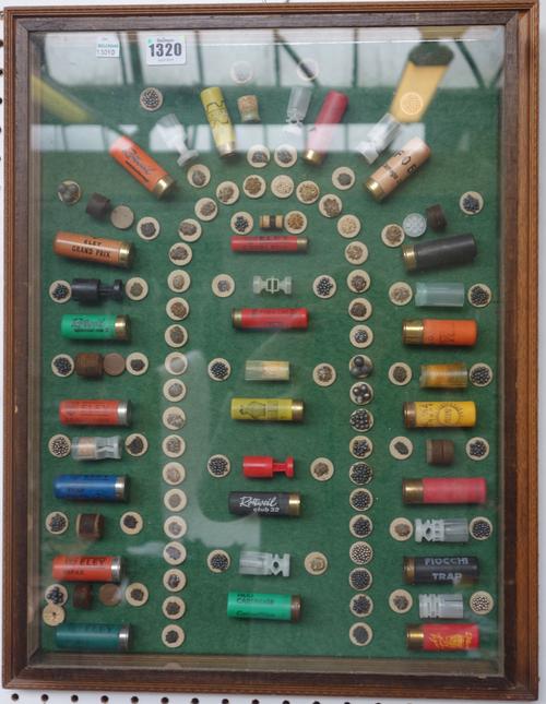 A quantity of shotgun cartridges framed as one in a glazed case, showing type and contents, and an early 20th century wooden leather bound cartridge c