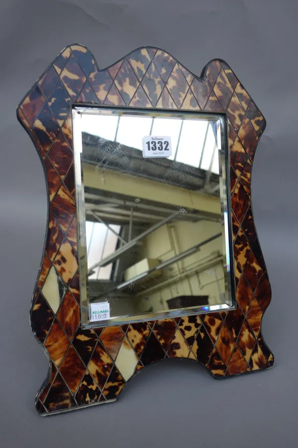 A tortoiseshell and inlaid table mirror, 19th century and later, of shaped outline, with an inset rectangular bevelled glass panel, 35.5cm high.