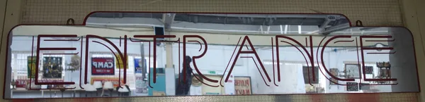 An Art Deco style 'Entrance' mirrored sign, on a red painted wooden board, 150cm wide.