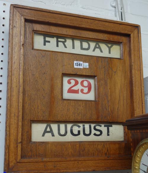 An early 20th century oak cased adjustable wall calendar, 51cm x 47cm x 11cm.