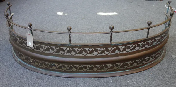 A Victorian patinated brass fire fender of curved form, with pillared top rail and parallel pierced foliate decoration, 151cm wide.
