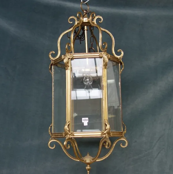 A Victorian style gilt metal hall lantern, 20th century, of hexagonal form, with scroll supports and foliate cast embellishments, 100cm high.