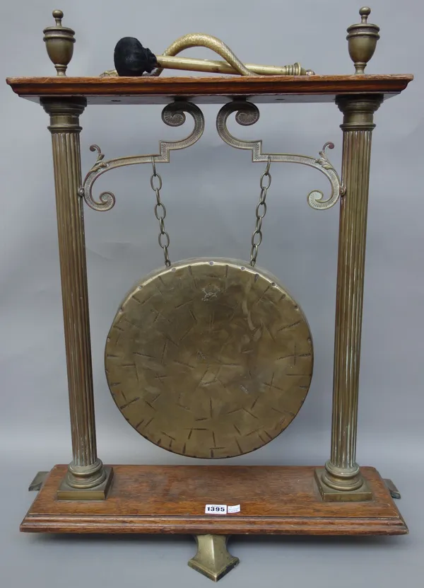 A Victorian brass and oak floor standing dinner gong, with Adams urn finials and serpent cast handle, 75cm high.