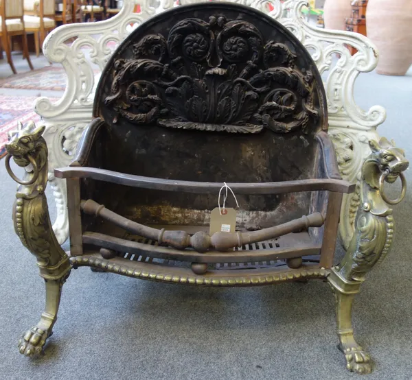 A Georgian style cast iron, steel and bronze mounted three bar fire grate, 20th century, of serpentine form, flanked by griffin supports, with a folia