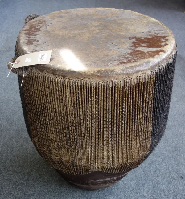 An African tribal drum of large proportions, 20th century, with leather hide and hair decoration to the circular body, 62cm high, 54cm dia.