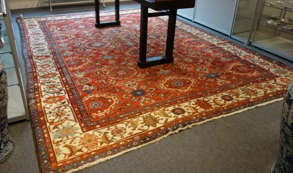 A fereghan carpet, Persian, the madder field with an allover design of flower head medallions, supporting sprays and motifs, an ivory palmette, leaf a