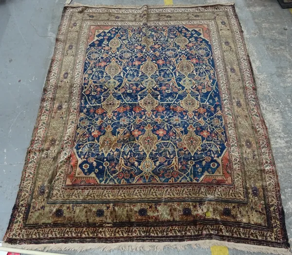 An antique silk Fereghan rug, deep blue main field with repeating polychrome floral decoration within olive green main border, 179cm x 134cm.