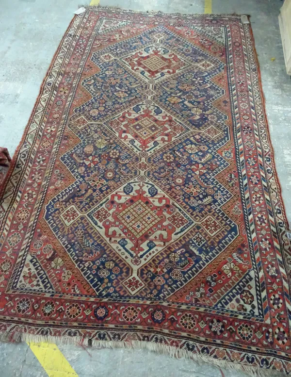 A Ghasghai rug, South Persian, the indigo field with three ivory diamonds, shaped madder surround, all with leaves and flowers, a madder flower border