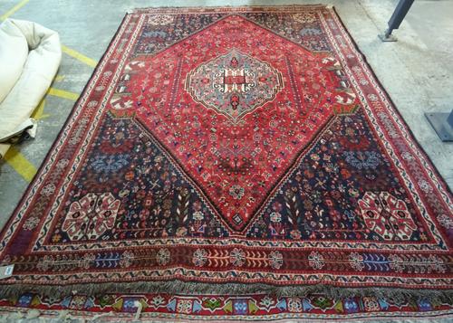 A Shiraz Persepolis carpet, S. Persian, the madder field with a central grey medallion, dark spandrels, all with minor floral motifs and birds; four s