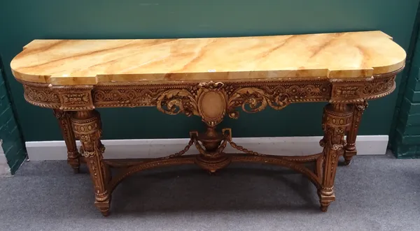 A console table in the mid-18th century French style, the faux marble top over a pierced and carved gilt base, on four tapering fluted supports united