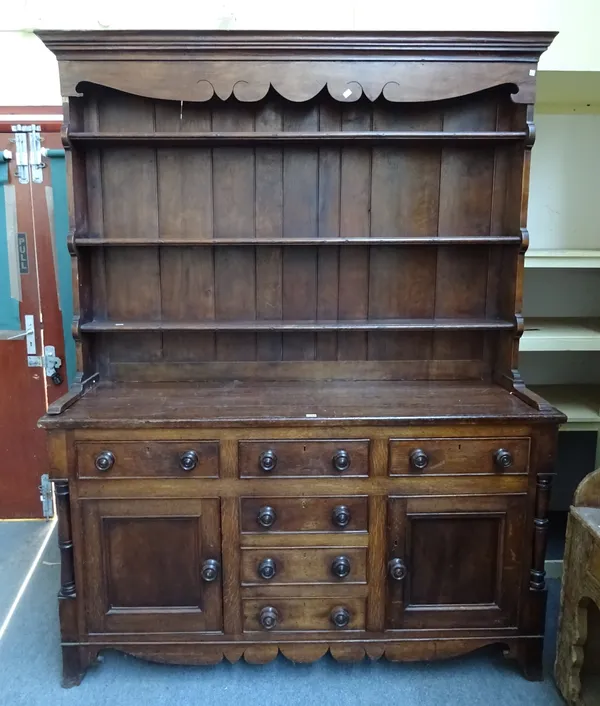 A 19th century oak dresser, the enclosed tier plate rack over six drawers and pair of cupboards flanked by columns, 170cm wide x 216cm high x 50cm dee