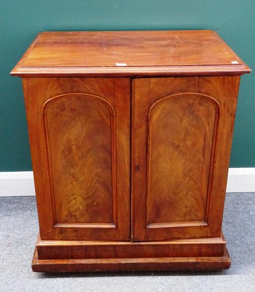A Victorian mahogany collector's chest, with pair of arched panel doors, enclosing four drawers, on plinth base, 80cm wide x 90cm high x 57cm deep.