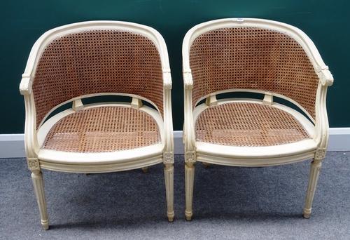 A pair of cream painted cane tub back chairs in the Louis XV style, on tapering fluted supports, 57cm wide x 79cm high (2).
