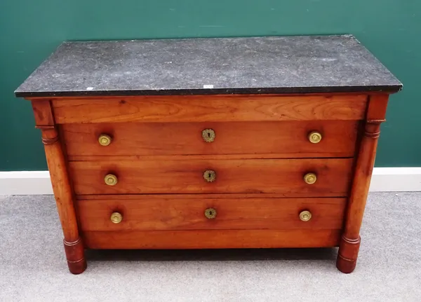 An early 19th century French commode, the rectangular marble top over a fruitwood four drawer base, flanked by turned columns, 130cm wide x 87cm high