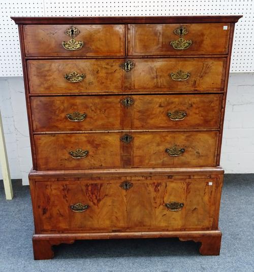 A George I featherbanded walnut chest of two short and three long graduated drawers, on associated single drawer base, on bracket feet, 109cm wide x 5