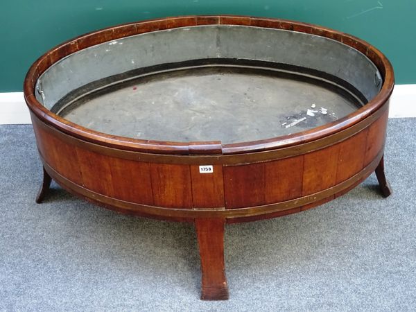 A large 20th century oval coopered oak wine cooler, on four splayed supports, 120cm wide x 53cm high x 78cm deep.