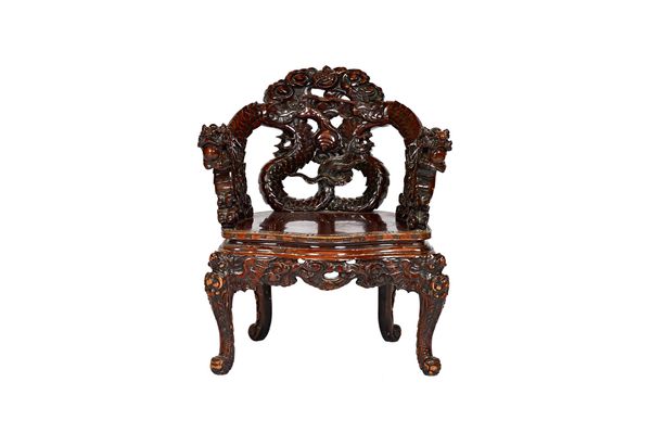 An early 20th century Chinese hardwood open armchair, the back relief carved as a pair of dragons chasing pearls, over solid seat on scroll supports,