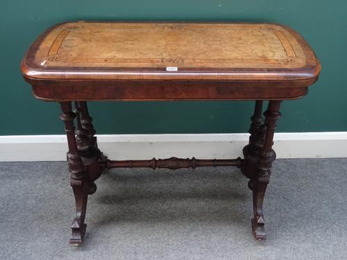 A Victorian inlaid walnut card table, the rounded rectangular top on four turned supports and downswept feet, 94cm wide x 75cm high x 48cm deep.