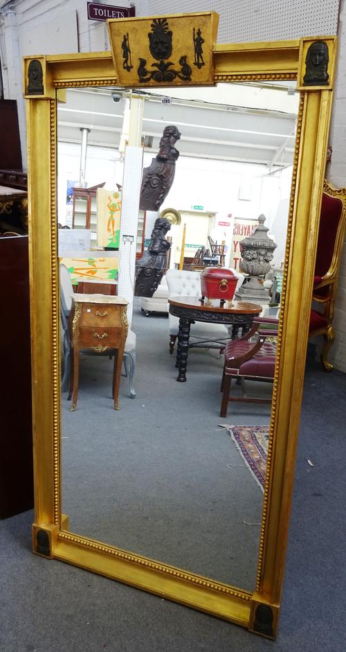 An early 19th century Egyptian Revival rectangular gilt frame wall mirror, with figural mounts and two part mirror plate, 94cm wide x 179cm high.