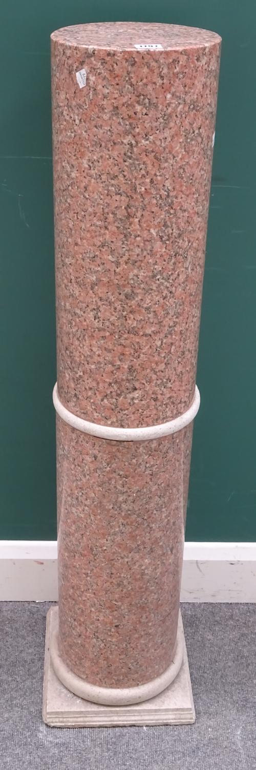 A carved pink granite column of cylindrical form on square base, 113cm high.