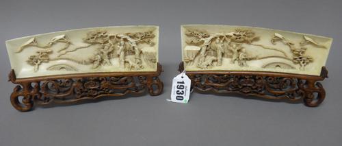 A pair of Chinese ivory wrist rests, late 19th century, each carved with with two boys flying kites observed by a woman carrying a child and a seated