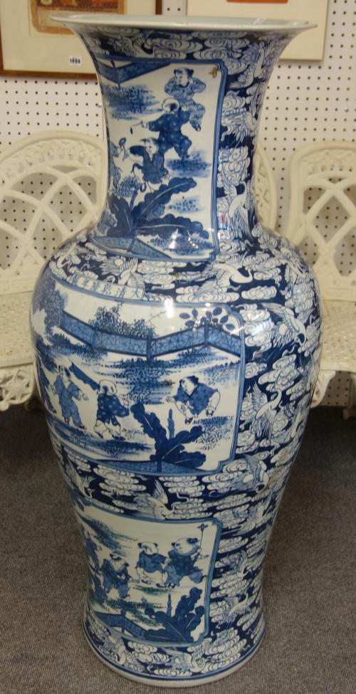 A pair of massive Chinese blue and white baluster vases, modern, decorated with panels of children at play, against a blue ground filled with white cr