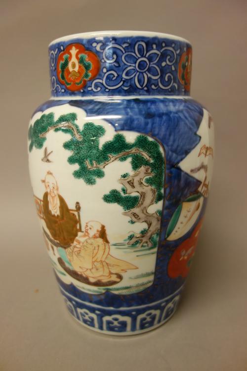 A Japanese Imari vase, early 20th century, of almost cylindrical form, each side painted with a panel of two figures seated in a landscape against a b