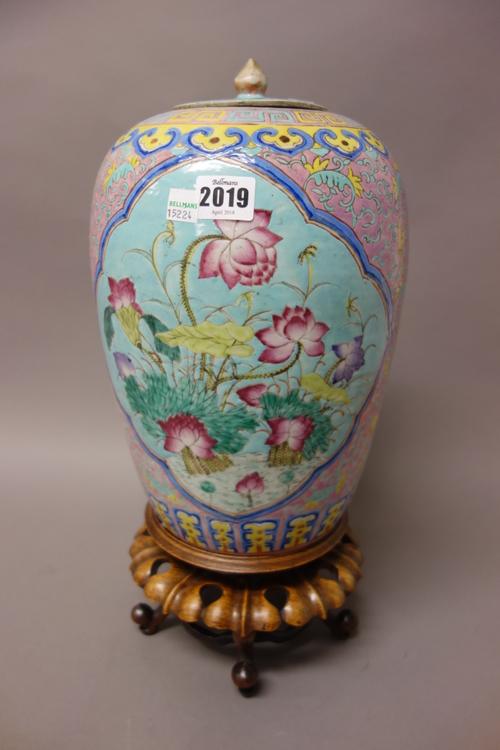 A Chinese famille-rose oviform jar and cover, late 19th/early 20th century, painted with two panels of lotus flowers against a deep pink ground filled