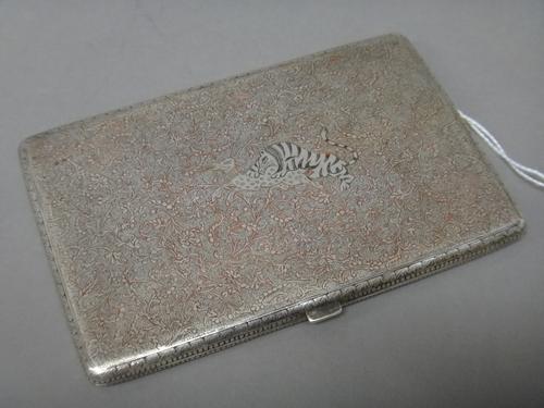 An Asian rectangular cigarette case, the back and the front engraved with a tiger taking its prey, in a foliate scrolling surround, unmarked, probably