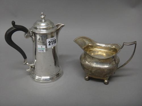 Silver, comprising; a hot water jug of tapering cylindrical form, with a black composition handle, Sheffield the date letter rubbed and a milk jug, wi